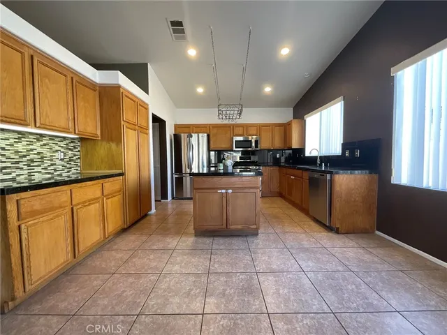 a kitchen with stainless steel appliances granite countertop a sink counter space cabinets and a large window