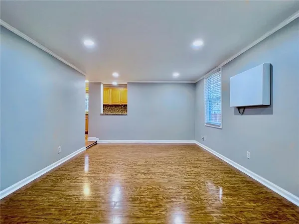 a view of empty room with wooden floor