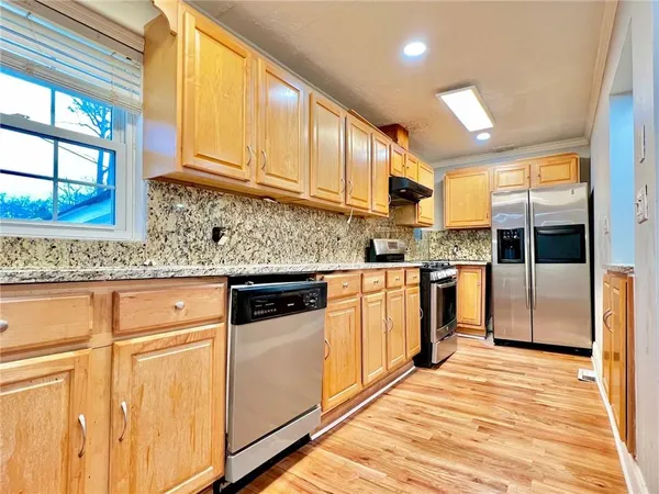 a kitchen with stainless steel appliances granite countertop a stove a sink and a refrigerator