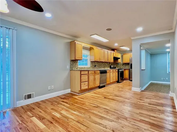 a large kitchen with kitchen island a sink stainless steel appliances and cabinets