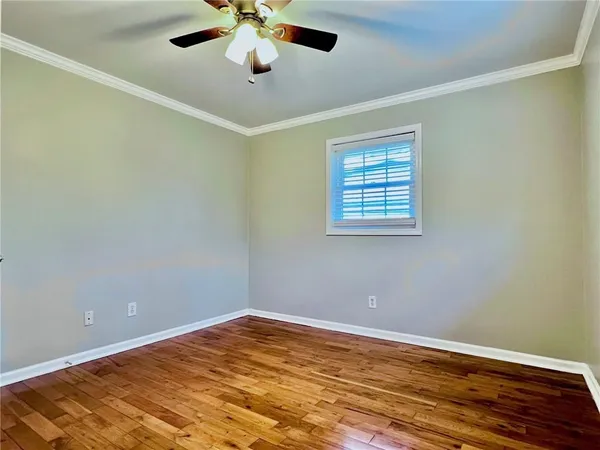 an empty room with a window and a ceiling fan