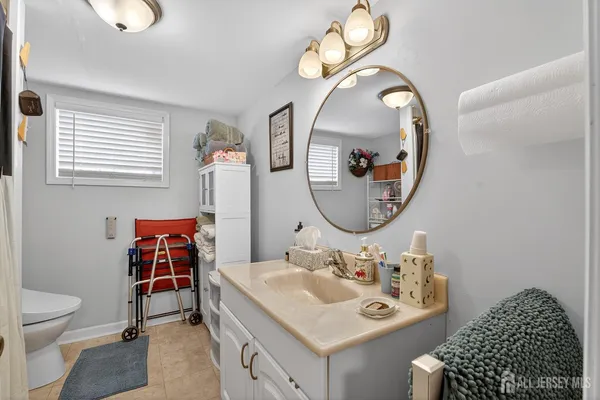 a bathroom with a sink a toilet and a mirror