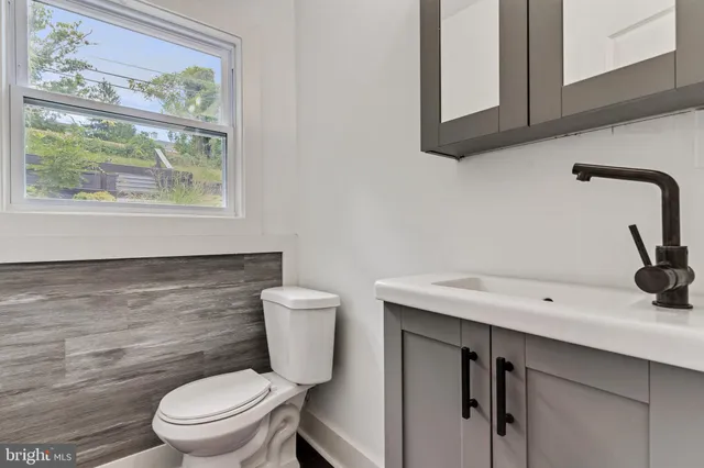 a bathroom with a toilet a sink and a window