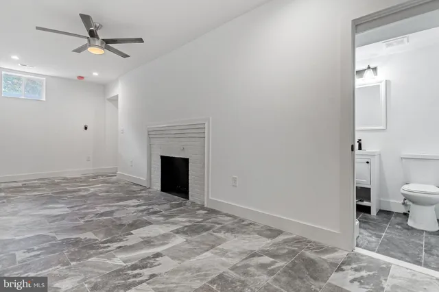 a view of a livingroom with a fireplace and a chandelier fan