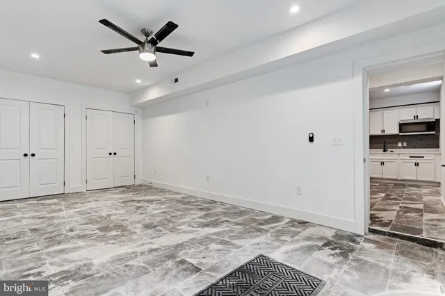 a view of a livingroom with wooden floor and a ceiling fan