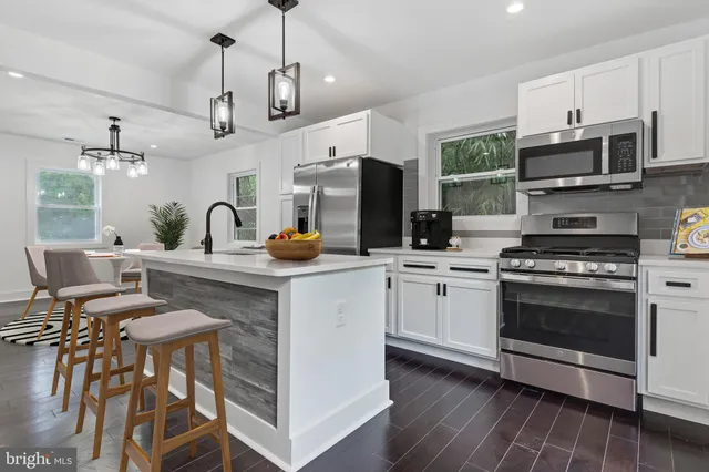a kitchen with stainless steel appliances a stove a sink a microwave and wooden cabinets