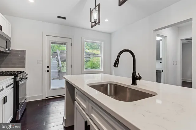 a close view of a sink and a refrigerator in a kitchen