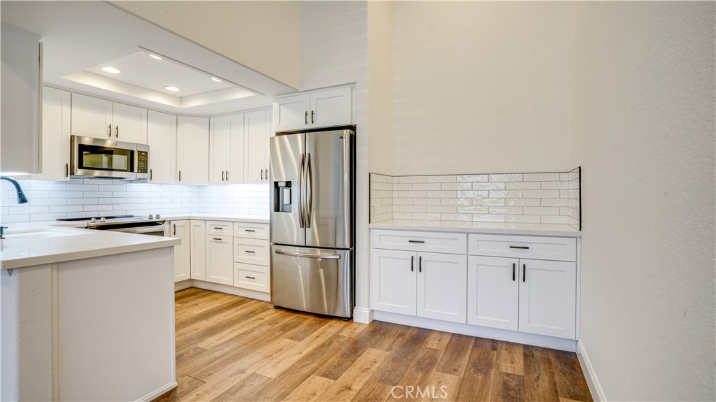 a kitchen with white cabinets and stainless steel appliances