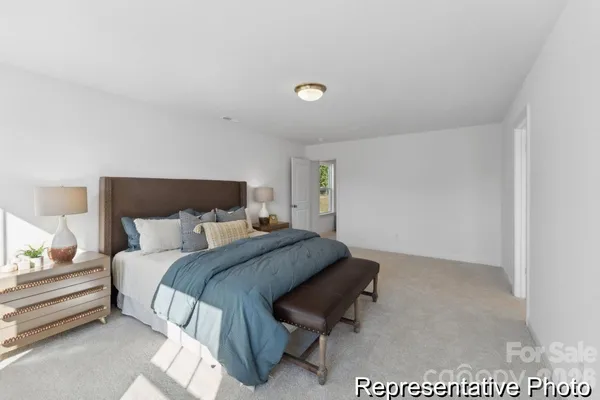 a bedroom with a bed and a lamp on dresser