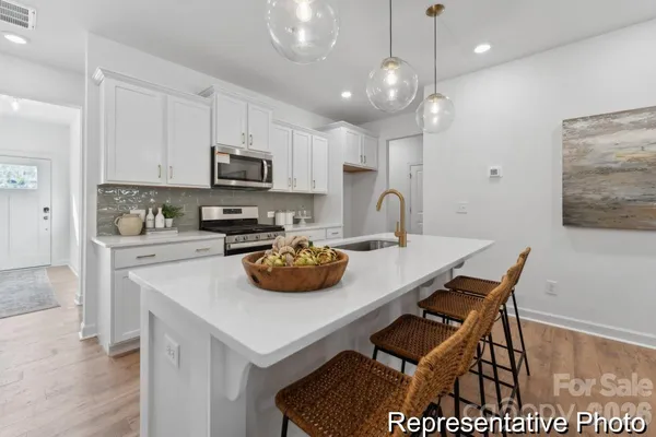 a kitchen with a sink a stove and chairs
