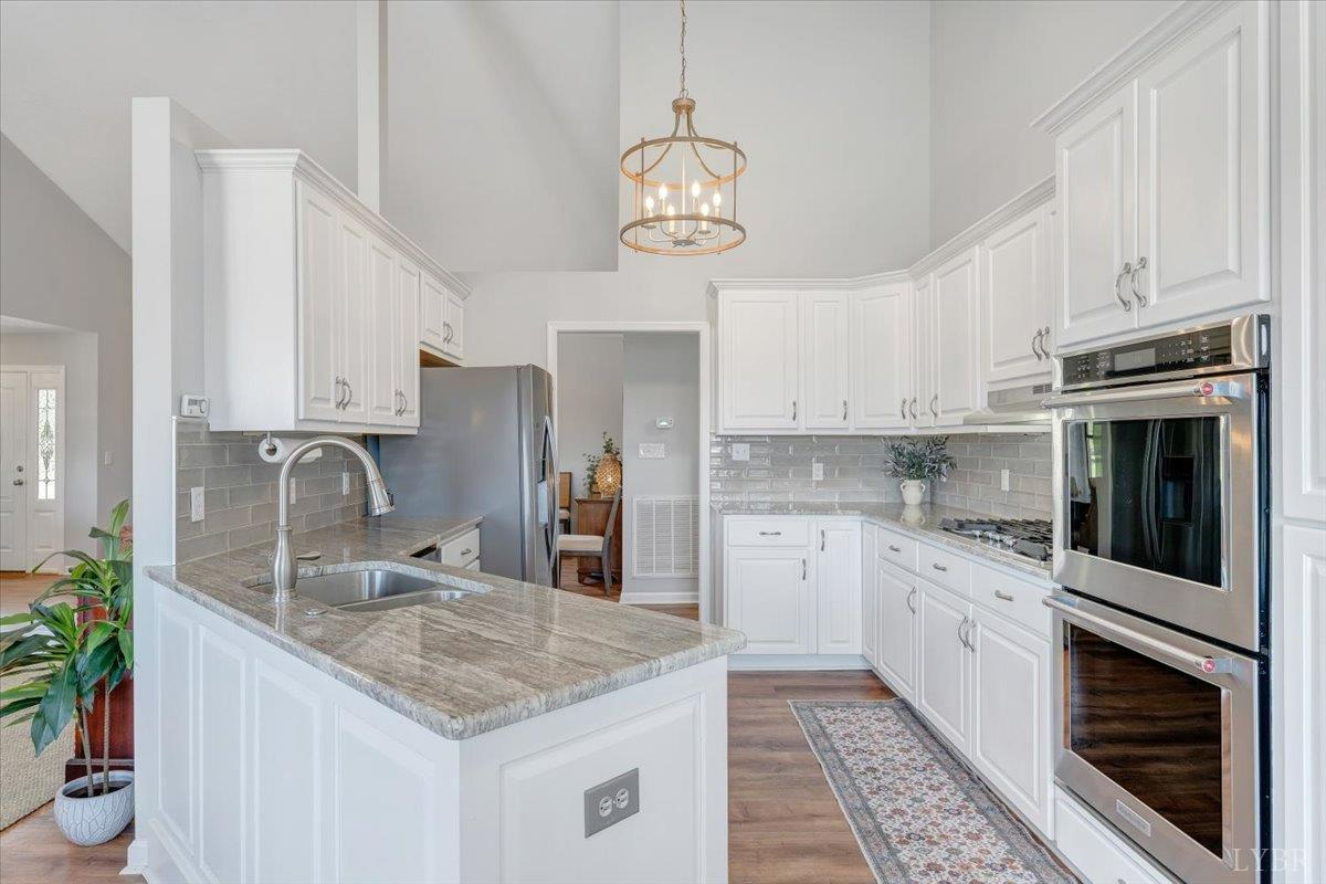 5129 Wheatland Road Bedford, VA 24523 - Photo 17 of 51 a kitchen with granite countertop a sink stainless steel appliances and white cabinets