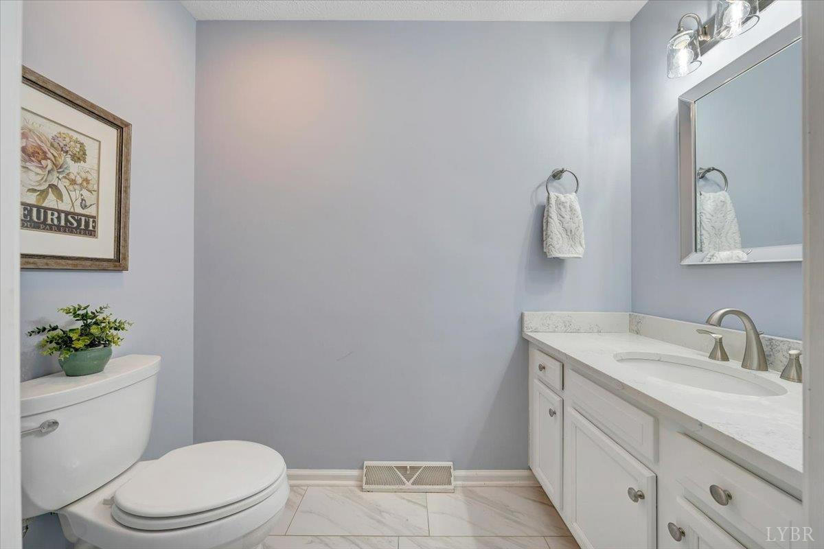 5129 Wheatland Road Bedford, VA 24523 - Photo 22 of 51 a bathroom with a toilet sink vanity and mirror