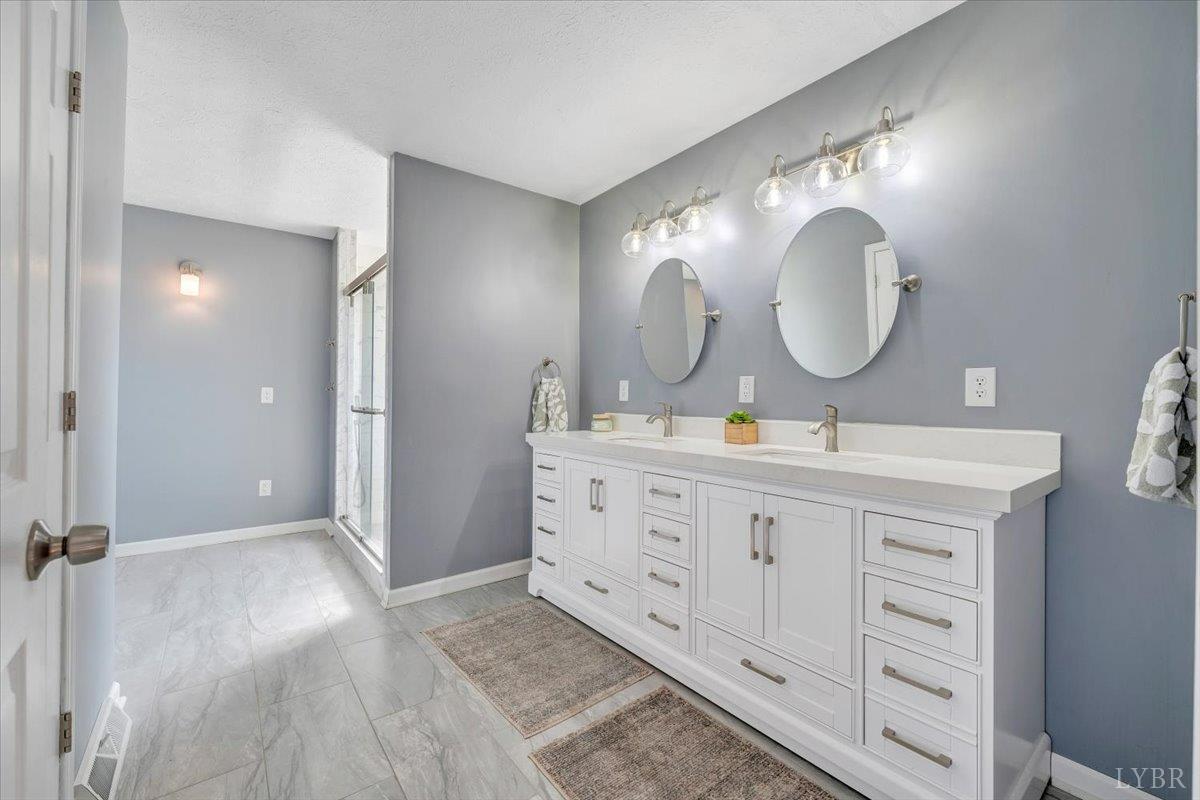 5129 Wheatland Road Bedford, VA 24523 - Photo 26 of 51 a bathroom with a double vanity sink and a mirror