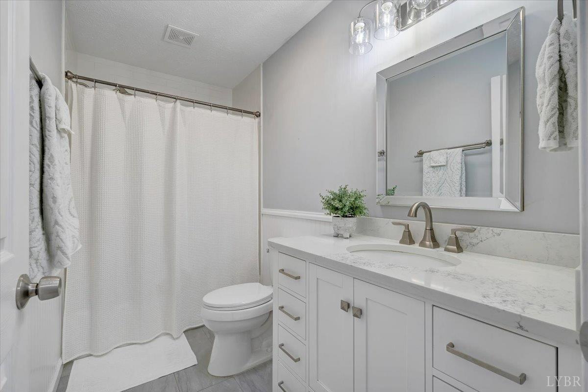 5129 Wheatland Road Bedford, VA 24523 - Photo 33 of 51 a bathroom with a granite countertop sink toilet and shower