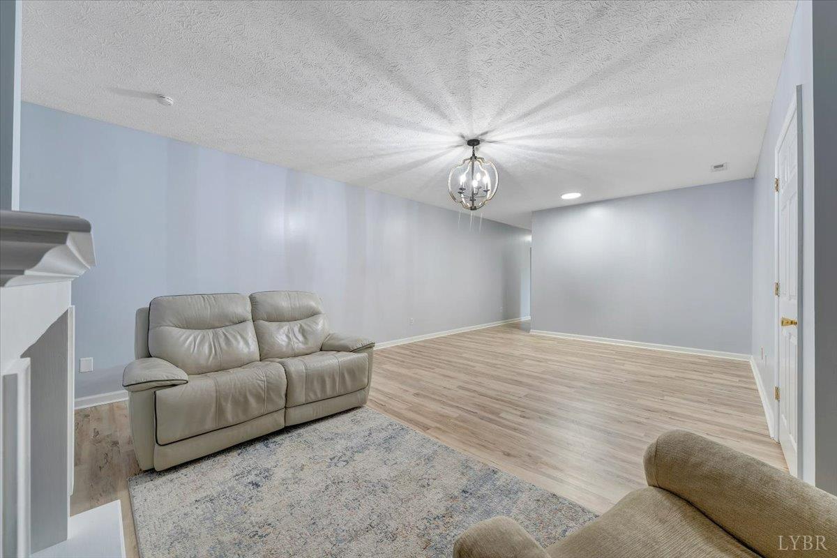 5129 Wheatland Road Bedford, VA 24523 - Photo 36 of 51 a living room with furniture and a chandelier