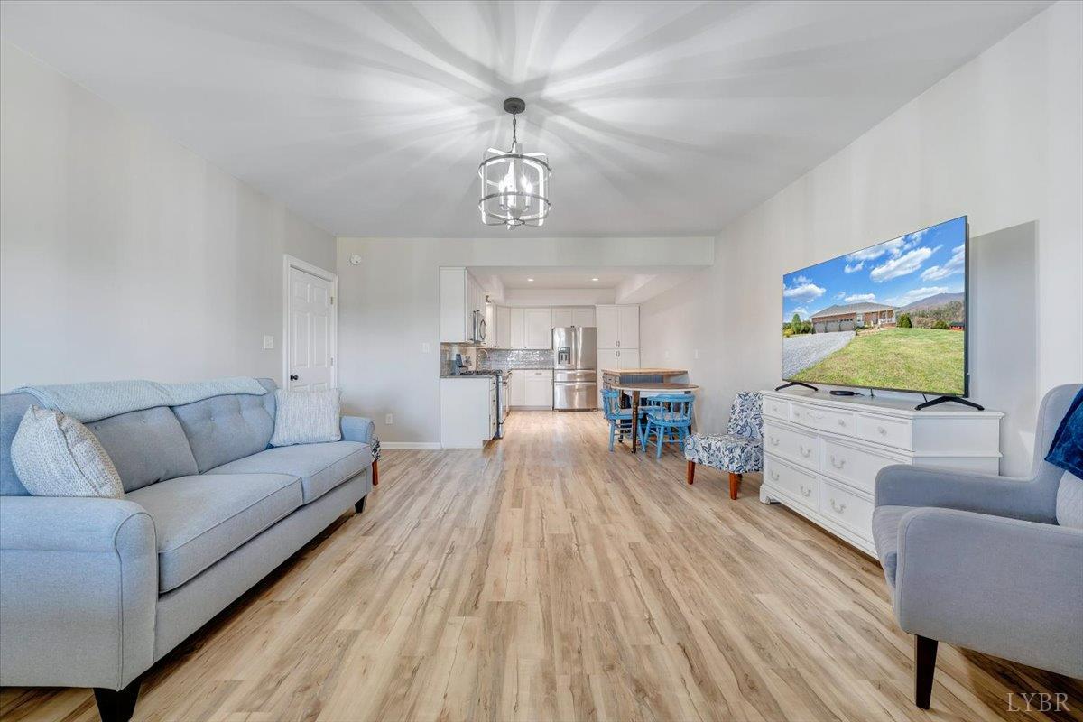 5129 Wheatland Road Bedford, VA 24523 - Photo 38 of 51 a living room with furniture and a chandelier