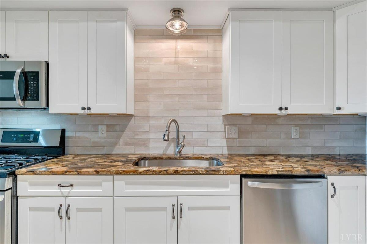 5129 Wheatland Road Bedford, VA 24523 - Photo 40 of 51 a kitchen with granite countertop a sink a stove and cabinets