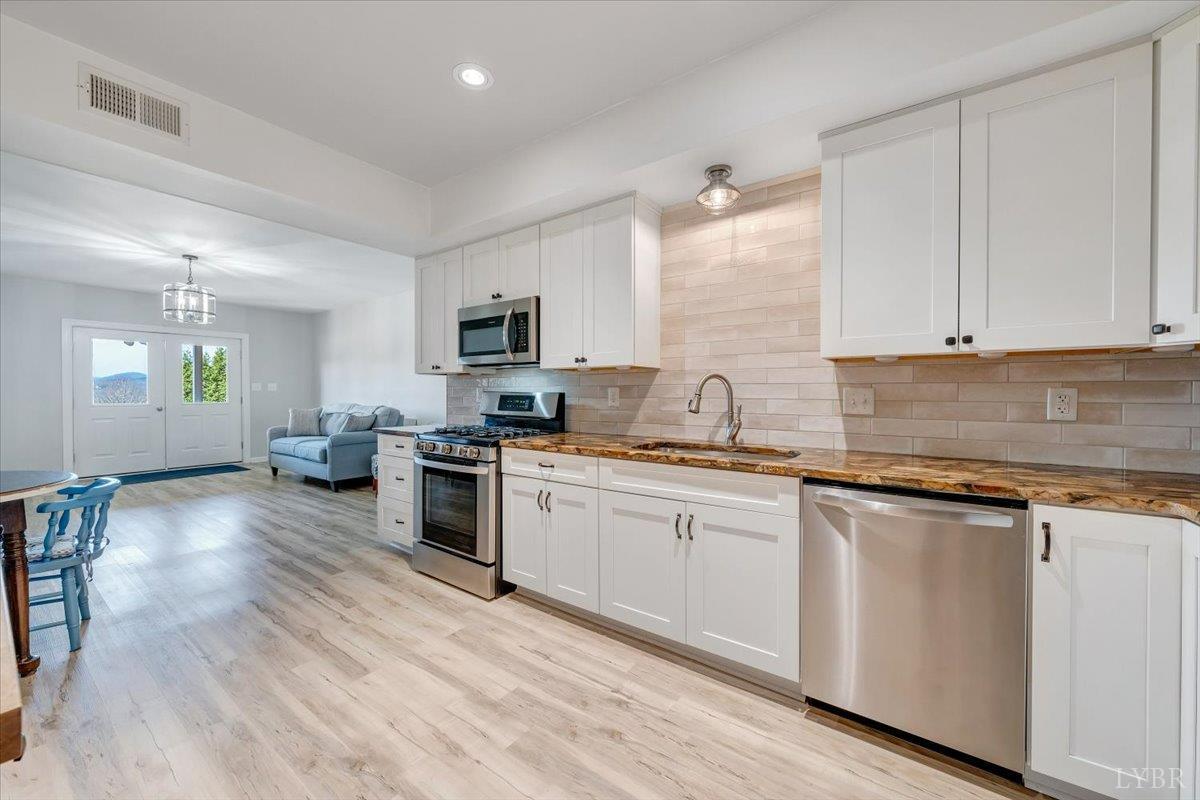 5129 Wheatland Road Bedford, VA 24523 - Photo 41 of 51 a kitchen with granite countertop white cabinets and white appliances