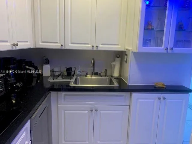 a kitchen with stainless steel appliances granite countertop white cabinets and sink