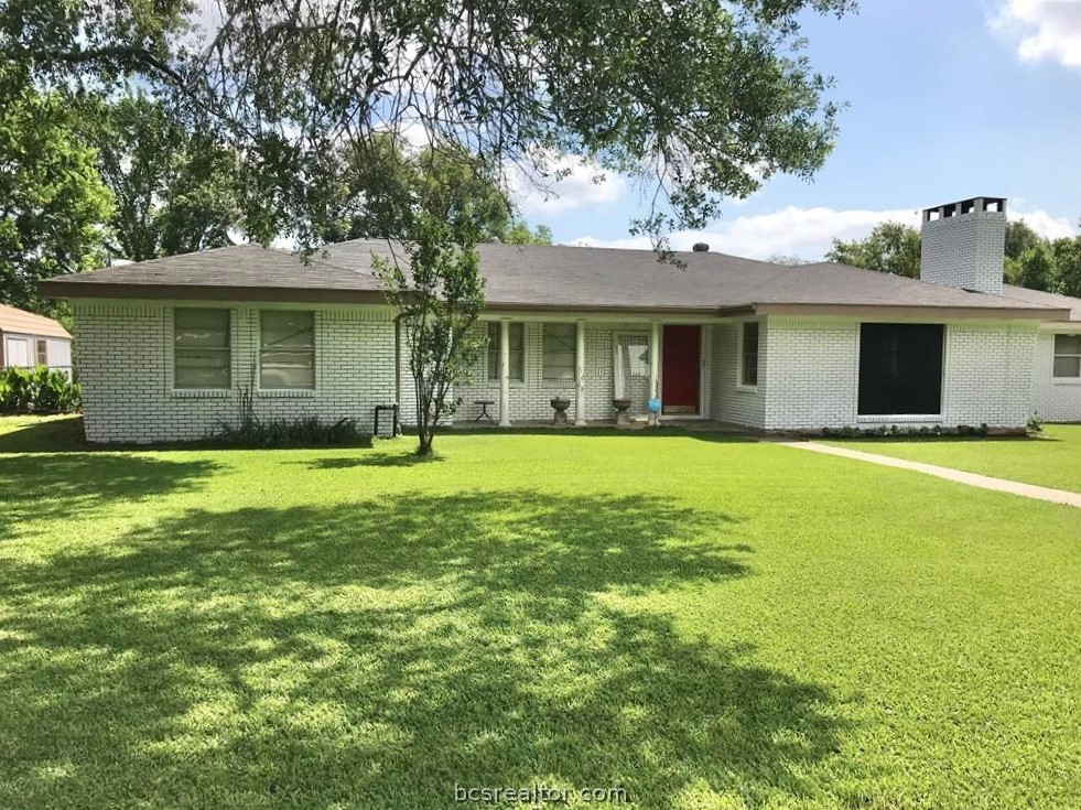 a front view of a house with yard and trees