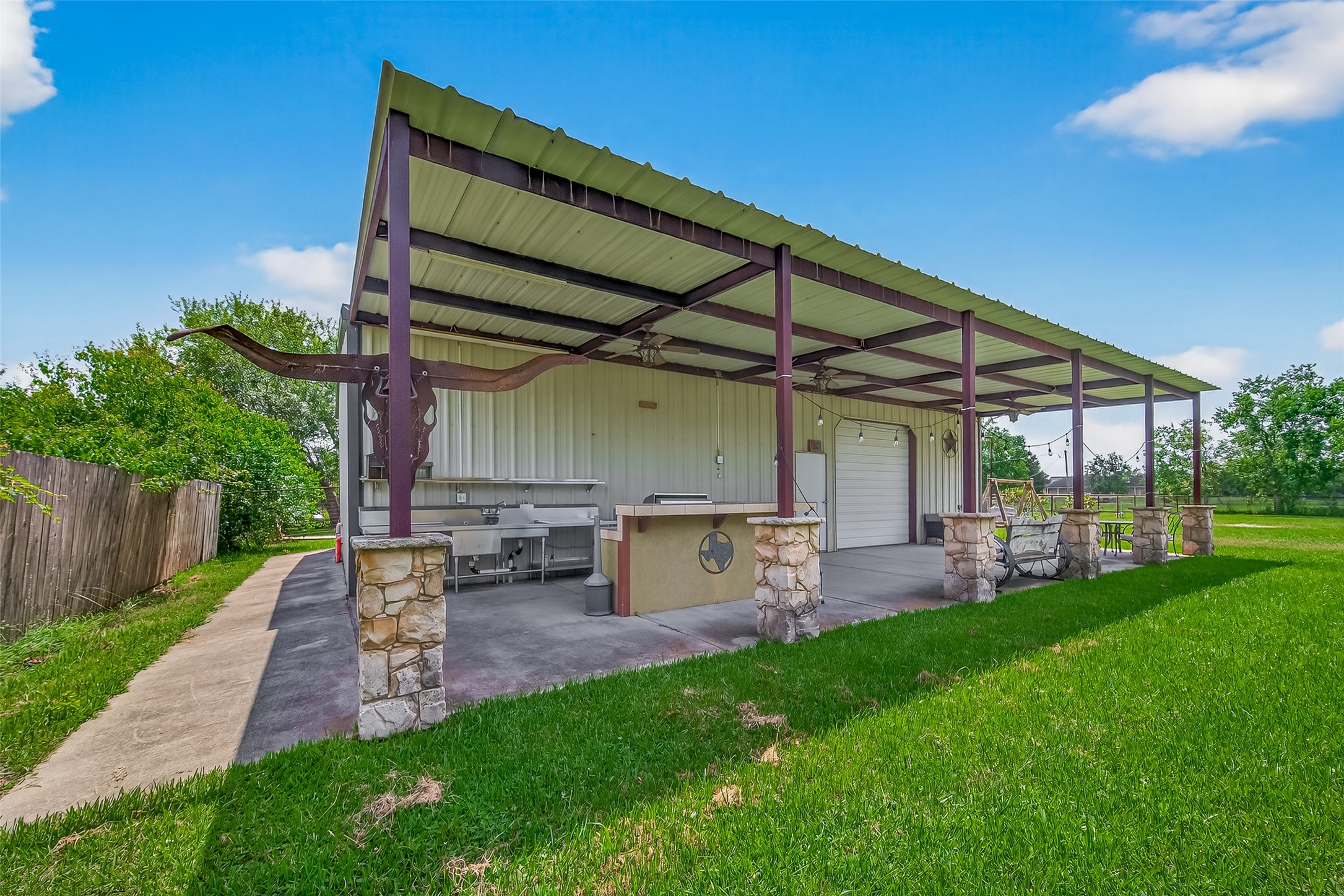 a view of a backyard with table and chairs under an umbrella with wooden fence