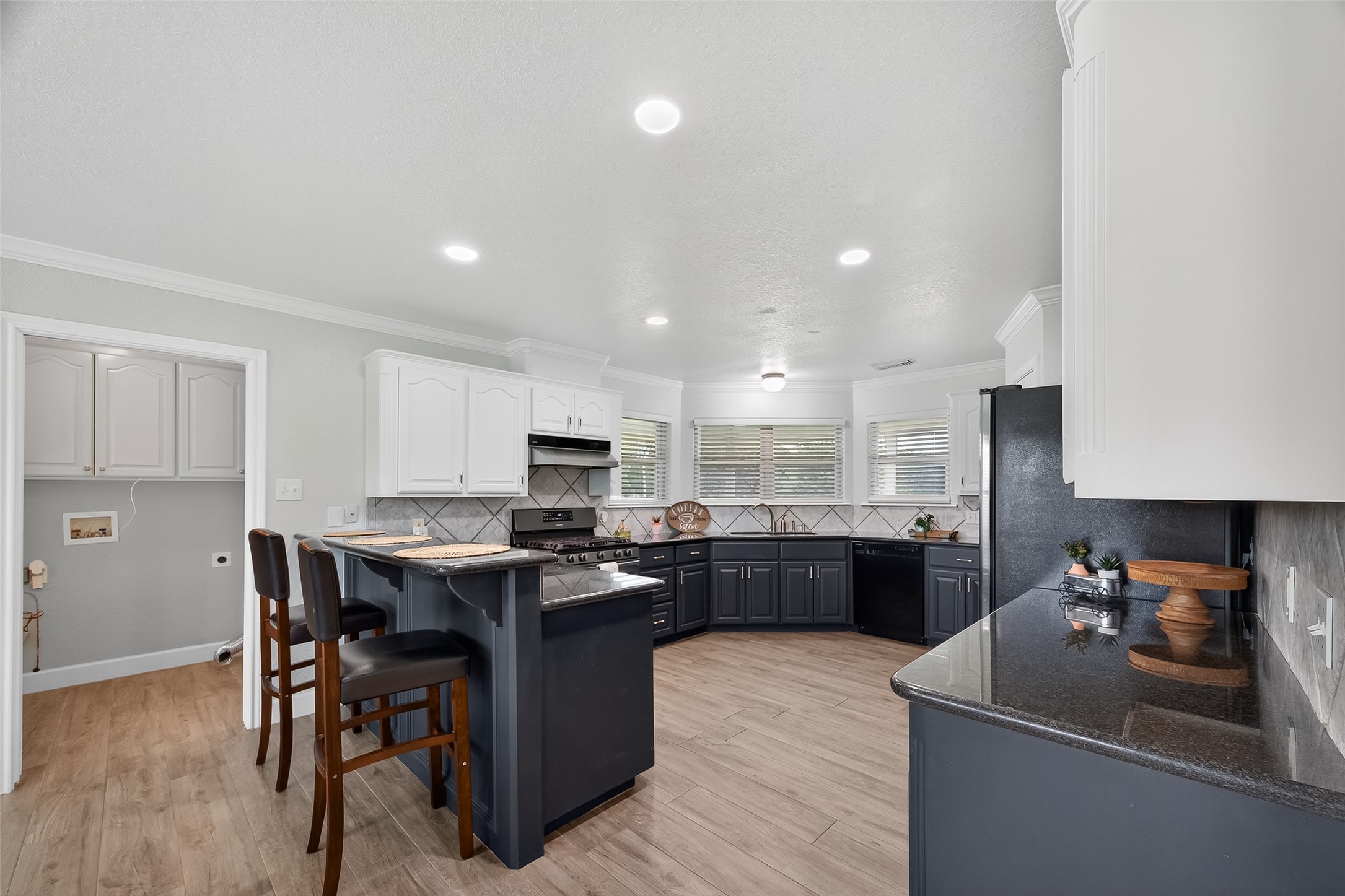 1030 Ginger Street Santa Fe, TX 77517 - Photo 14 of 50 a kitchen with kitchen island granite countertop a sink a stove a counter top space and cabinets