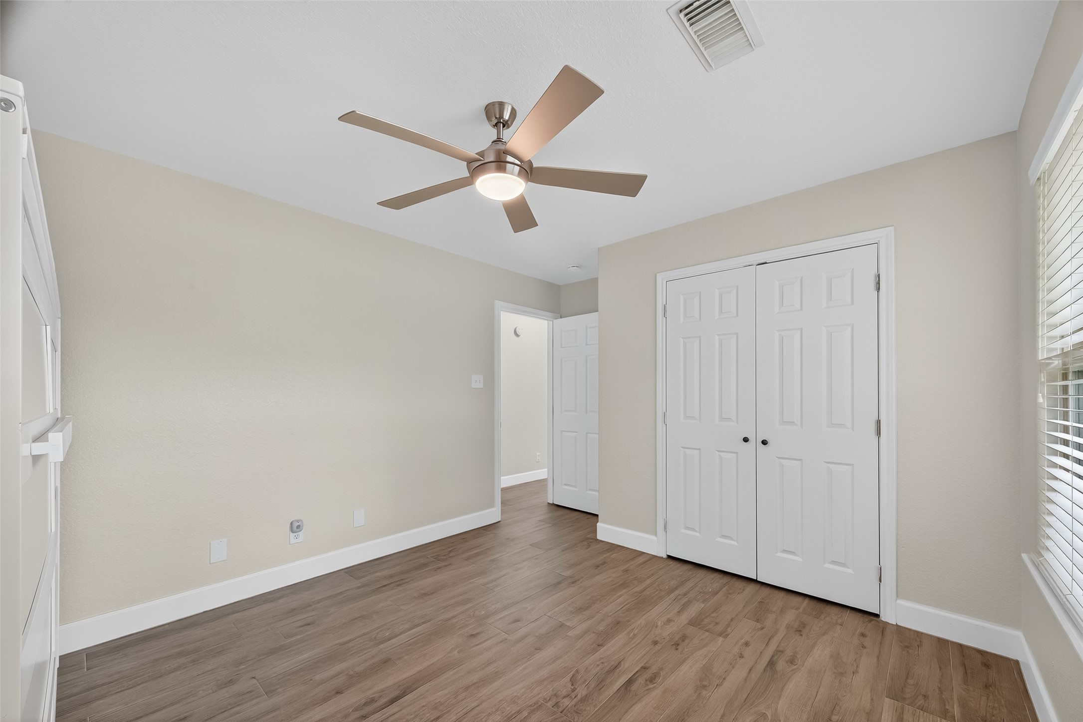 1030 Ginger Street Santa Fe, TX 77517 - Photo 21 of 50 an empty room with wooden floor fan and windows