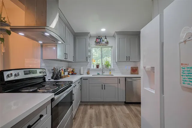 a kitchen with kitchen island granite countertop a sink cabinets and stainless steel appliances