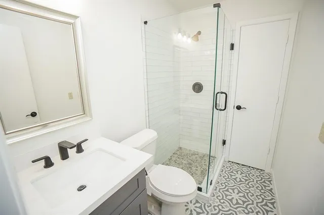 a bathroom with a sink a toilet and shower