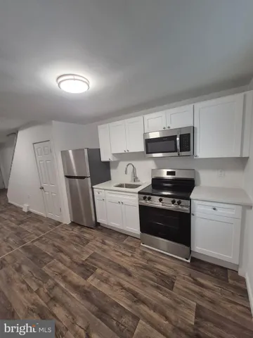 a kitchen with stainless steel appliances a stove a microwave a sink and cabinets