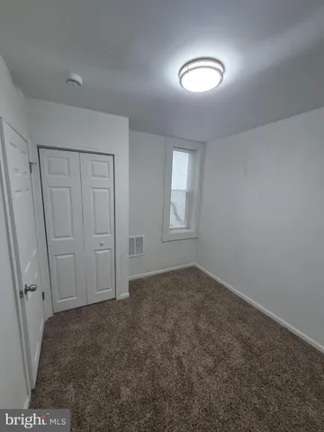 an empty room with windows and closet