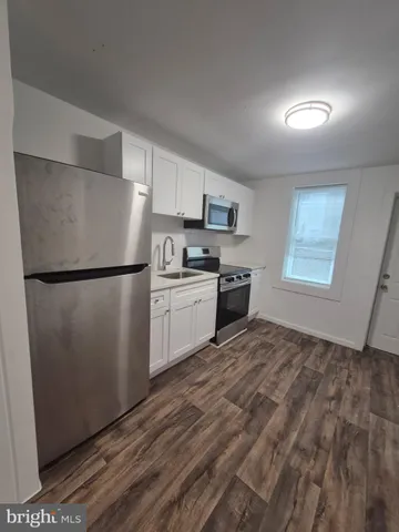a kitchen with stainless steel appliances granite countertop a refrigerator sink and stove