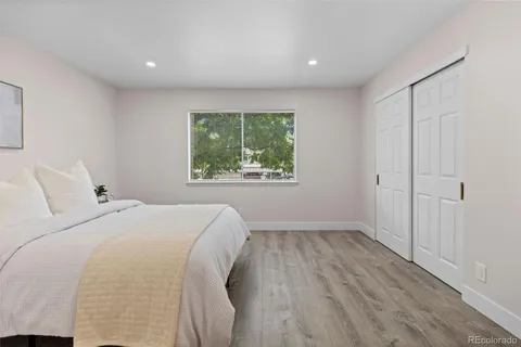 a bedroom with a bed and a white wall painting