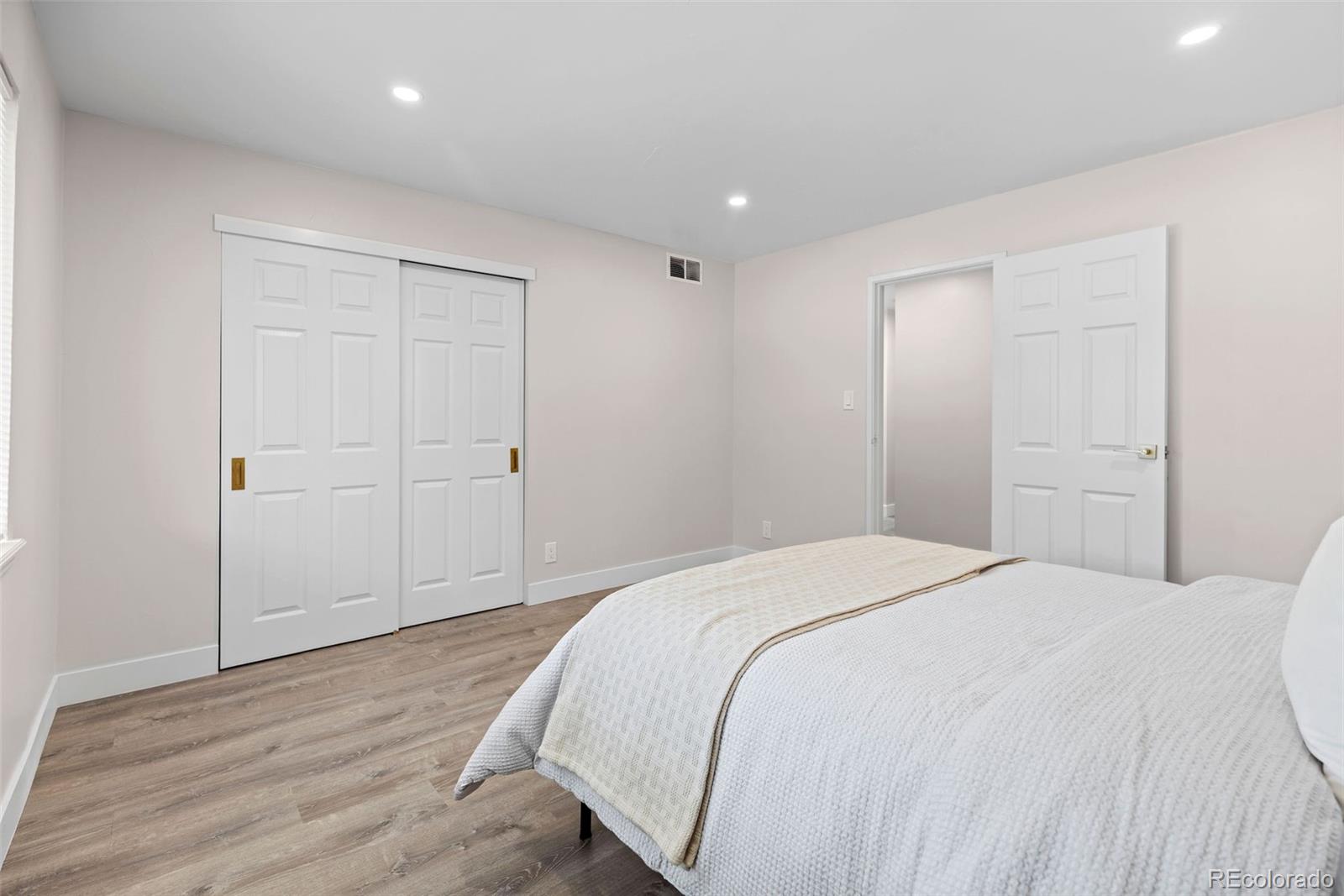 7495 East Quincy Avenue, Unit 202 Denver, CO 80237 - Photo 17 of 28 a spacious bedroom with a bed and wooden floor