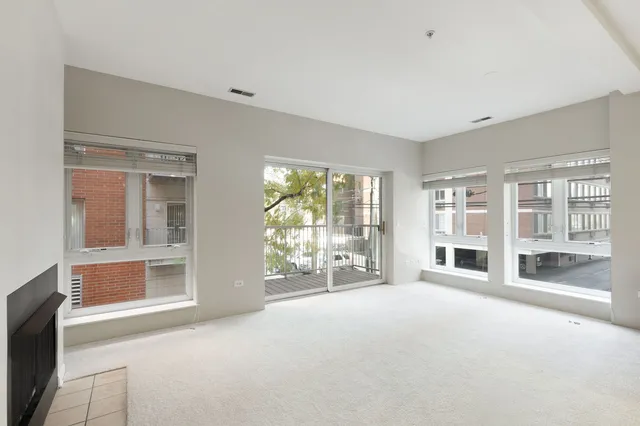 a view of an empty room with a fireplace and a large window