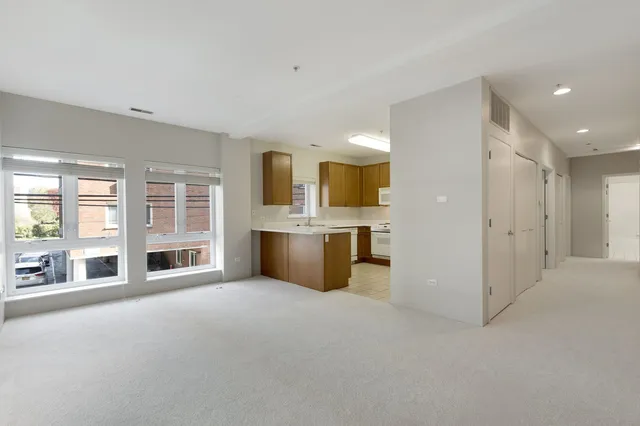 a large white kitchen with a sink and cabinets