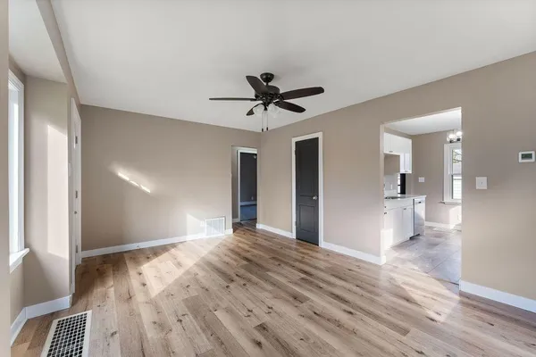 a view of a livingroom with a ceiling fan and wooden floor