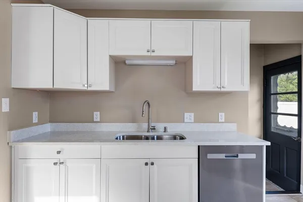 a kitchen with granite countertop white cabinets and a sink