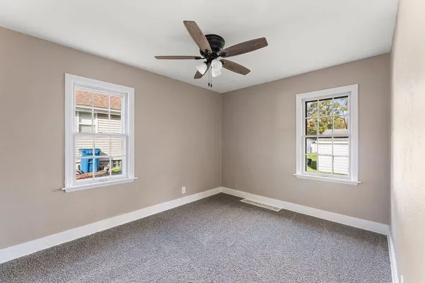 an empty room with a window and a ceiling fan