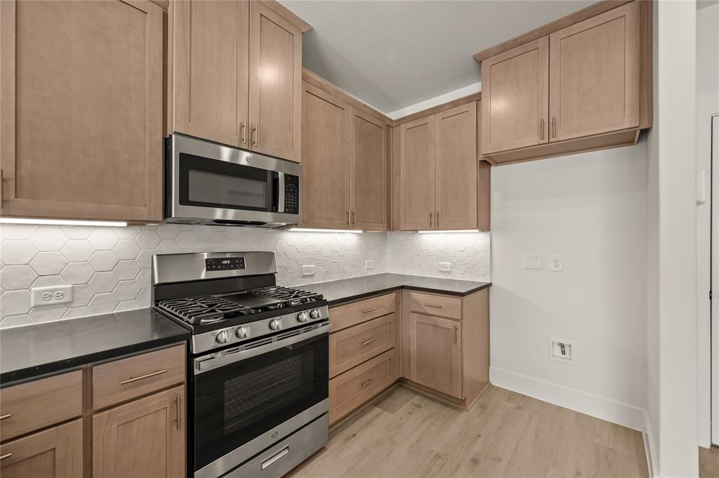 2550 Brunswick Way Allen, TX 75013 - Photo 11 of 24 a kitchen with cabinets stainless steel appliances and wooden floor