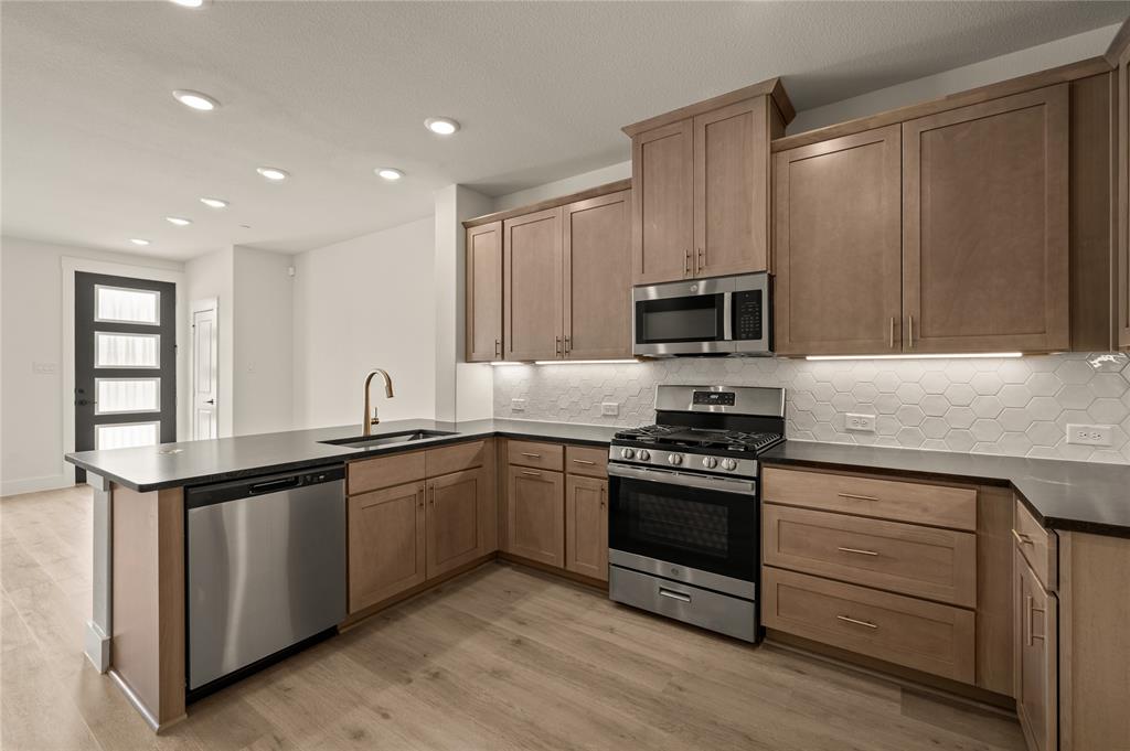 2550 Brunswick Way Allen, TX 75013 - Photo 10 of 24 a kitchen with stainless steel appliances granite countertop a stove a sink and a microwave
