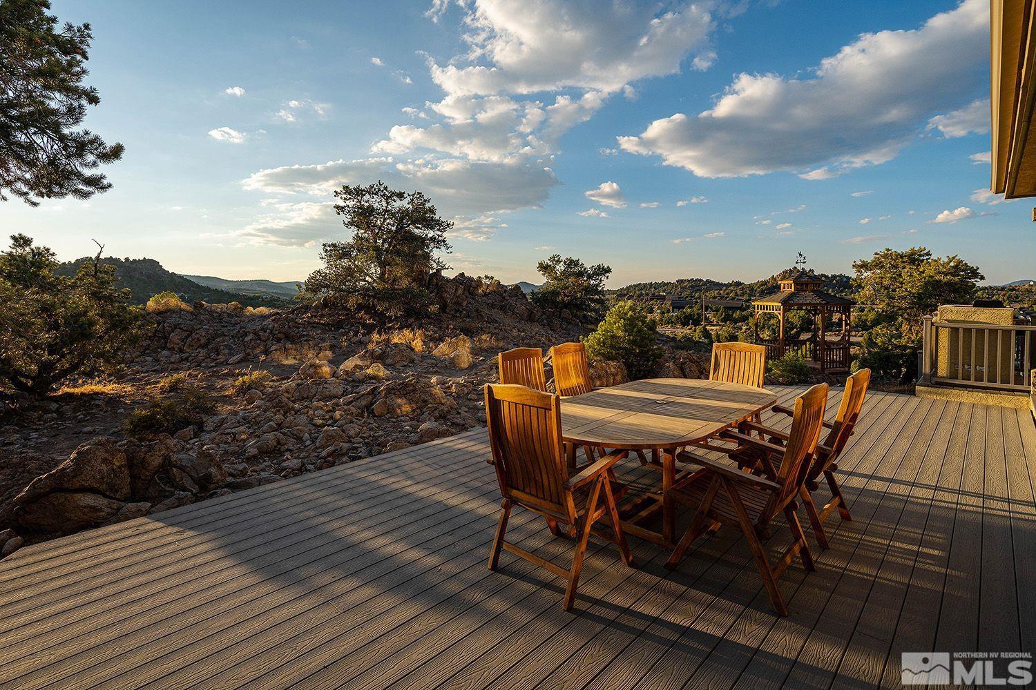 4530 Lousetown Road Reno, NV 89521 - Photo 30 of 39 a view of a roof deck with table and chairs with wooden floor and fence