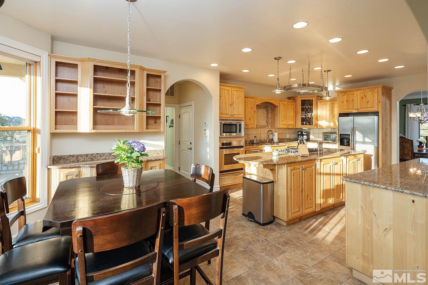 4530 Lousetown Road Reno, NV 89521 - Photo 9 of 39 a kitchen with sink refrigerator dining table and chairs