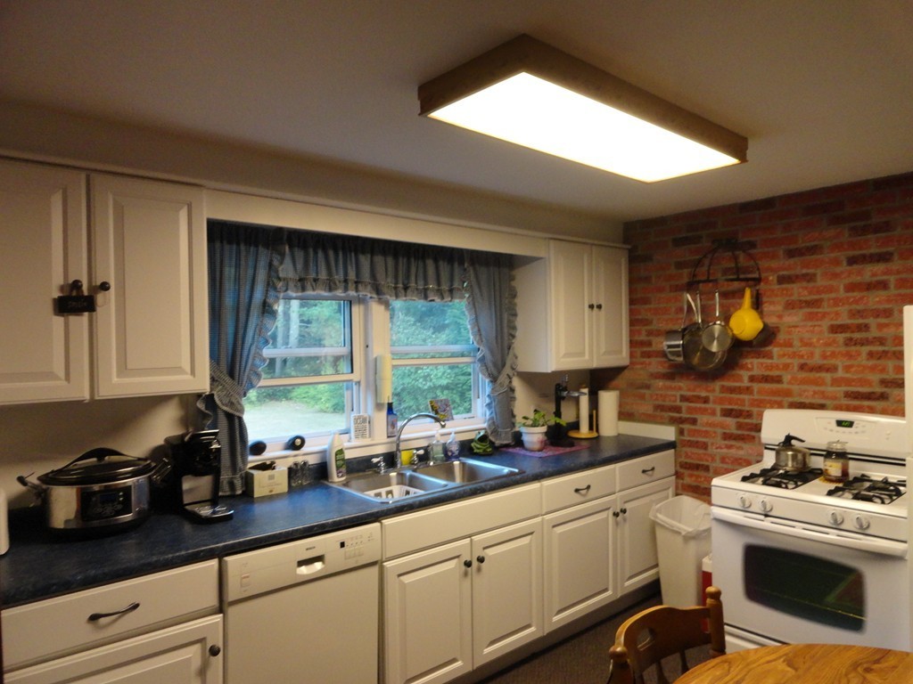 24 Warren Road Townsend, MA 01469 - Photo 3 of 15 a kitchen with sink a stove and white cabinets