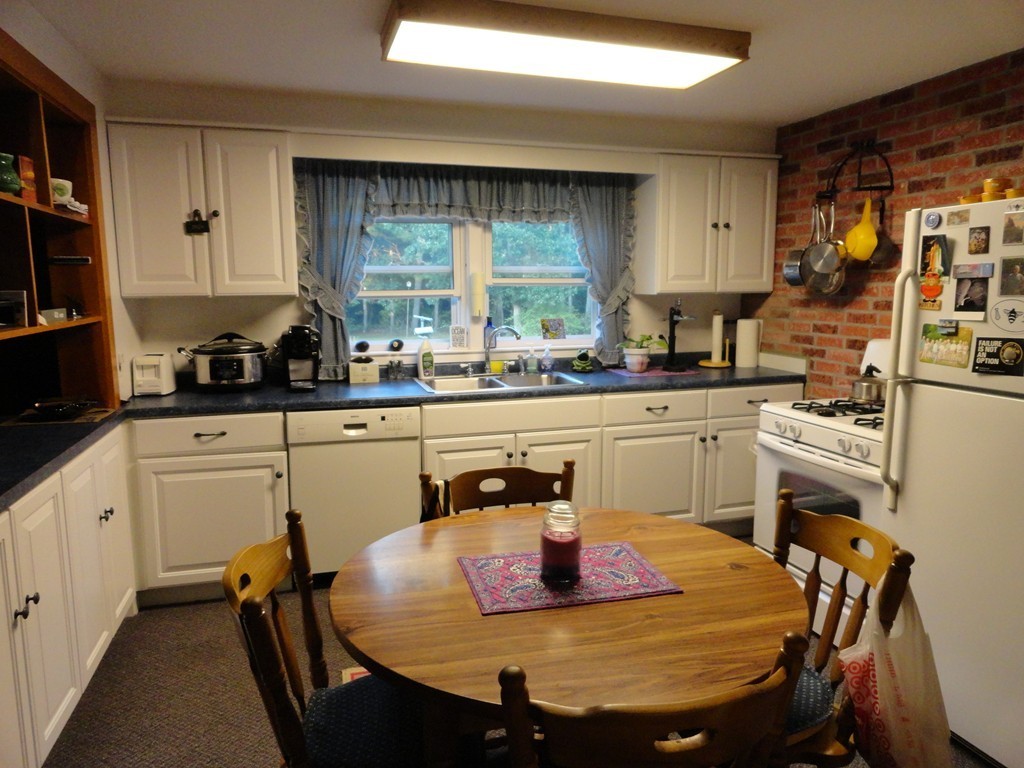 24 Warren Road Townsend, MA 01469 - Photo 4 of 15 a kitchen with a sink a stove and chairs