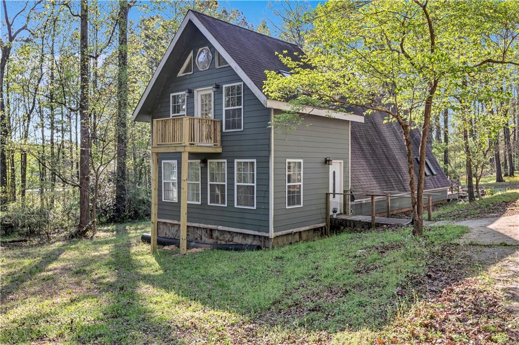 a view of a house with a yard and large trees