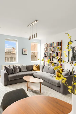 a kitchen with stainless steel appliances granite countertop a sink a stove a microwave oven a refrigerator with white cabinets and wooden floor