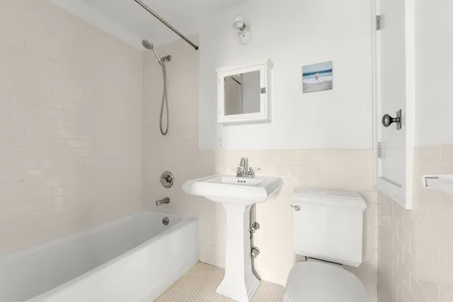 a bedroom with a bed and painting on the wall