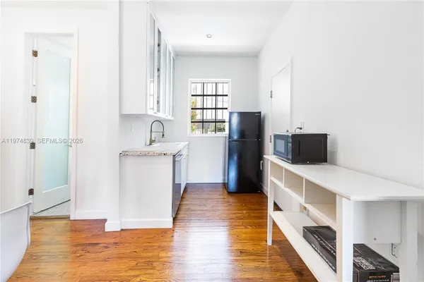 a kitchen with granite countertop a stove a sink and a refrigerator