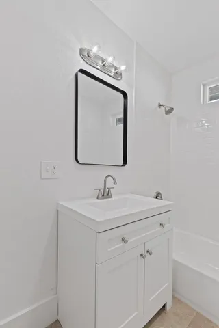 a bathroom with a sink vanity and mirror